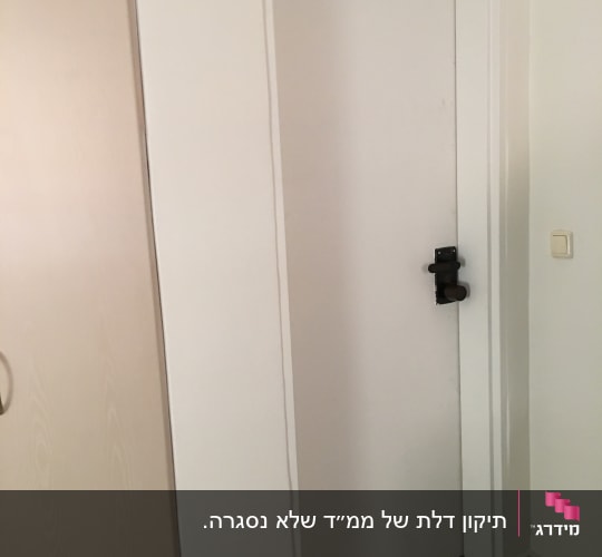 דלת לבנה עם מנעול בריח שחור